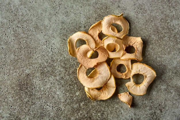 Gedehydrateerde appels chips op getextureerde houten achtergrond bovenaanzicht kopie ruimte