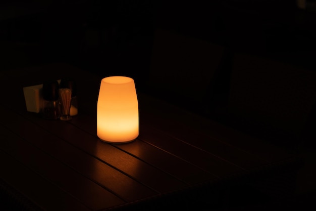 Gedempt licht van een lamp op een tafel 's nachts in een café-kopieerruimte