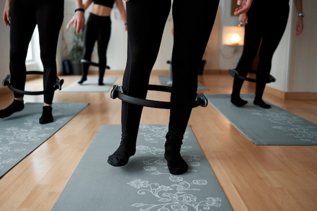 Gedetailleerde tekening van vrouwen die de Pilates-beenring gebruiken