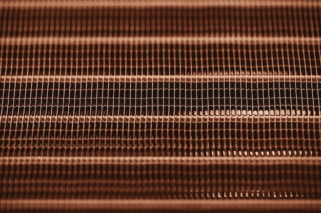 Gedetailleerde textuurmotor waterkoelradiator met horizontale lijnen. oranje auto-onderdeel met copyspace close-up.