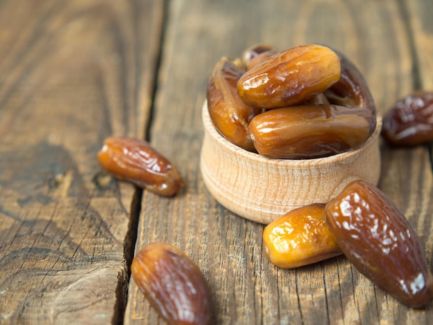 Gedroogd dadelfruit in kom op de oude houten tafel