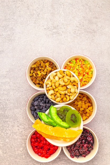 Gedroogd en gekonfijt fruit en cashewnoten in keramische kommen