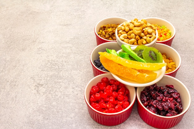 Gedroogd en gekonfijt fruit en cashewnoten in keramische kommen