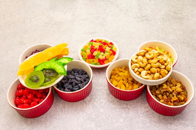 Gedroogd en gekonfijt fruit en cashewnoten in keramische kommen