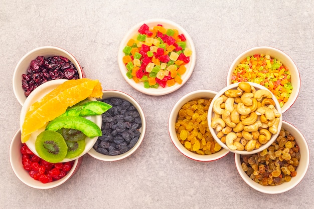 Gedroogd en gekonfijt fruit en cashewnoten in keramische kommen