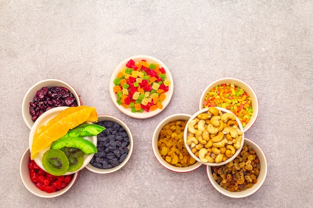 Gedroogd en gekonfijt fruit en cashewnoten in keramische kommen