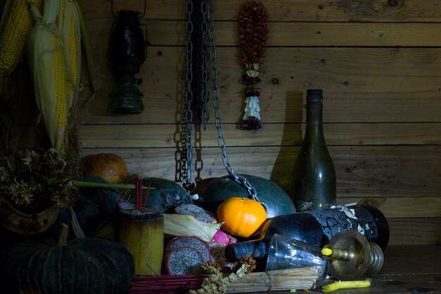 Gedroogd fruit en fles op hout in kamer met weinig licht.