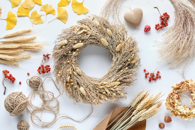 Gedroogd pampagras krans gebroken witte tafel met ginko bladeren stenen lijsterbessen pampagras en hennepkoord kartonnen hart herfst achtergrond natuurlijke herfst huis decor bovenaanzicht plat leggen