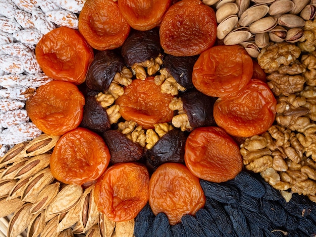 Foto gedroogde abrikozen rozijnen en noten ronde samenstelling cirkel verdeeld in delen gemaakt van noten en gedroogde abrikozen concept van gezonde snack verschillende noten en gedroogde vruchten close-up