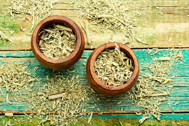 Foto gedroogde alsem in een kom, homeopathische kruiden in de kruidengeneeskunde.