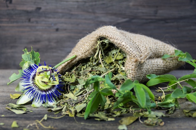 Gedroogde bladeren van passiflora om kalmerende thee op houten achtergrond te drinken