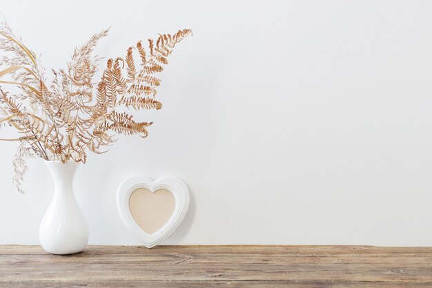 Gedroogde bloemen in vaas op houten tafel op witte achtergrond