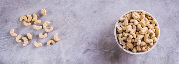 Gedroogde cashewnoten in een kom op tafel voor een vegetarisch dieet bovenaanzicht webbanner