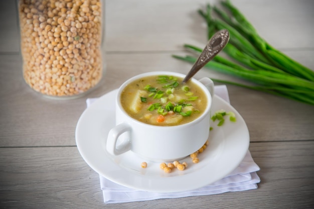 gedroogde erwtensoep in een bord met kruiden op een houten tafel