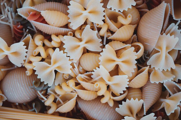 Gedroogde gemengde pasta op een donkere houten tafel Samenstelling van rauwe Italiaanse pasta Rauwe pasta achtergrond