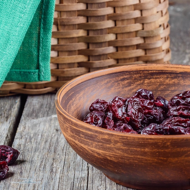 Gedroogde kersen in een kleiplaat op een houten tafel in een rustieke stijl