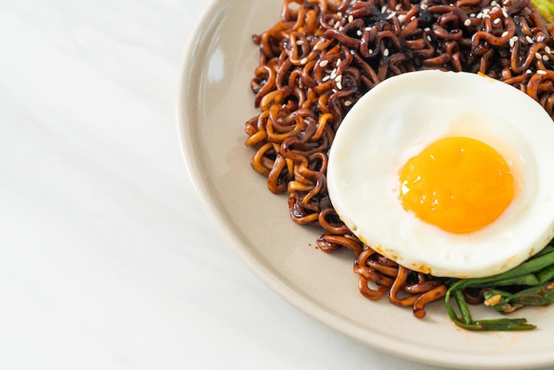 Gedroogde Koreaanse pittige zwarte saus instant noedels met gebakken ei en kimchi