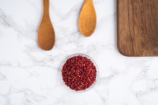 Gedroogde roze pepernoten in een houten kom met twee houten lepels