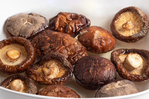 Gedroogde shiitake-paddenstoelen die in water worden geweekt.