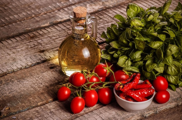 Foto gedroogde tomaten, basilicum en olie op een houten ondergrond