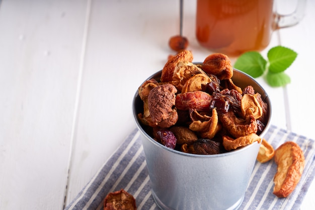 Gedroogde vruchten en zelfgemaakte compote van gedroogde vruchten in een pot op een lichte tafel.