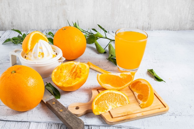 Gedrukt jus d&#39;orange en verse sinaasappelenvruchten op witte houten lijst. Eigengemaakt