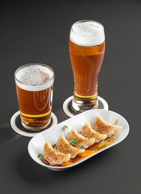 Gedza dumplings with beer on a gray background