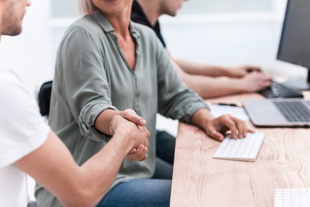 Geef werknemers de hand op de werkplek bij de desktop