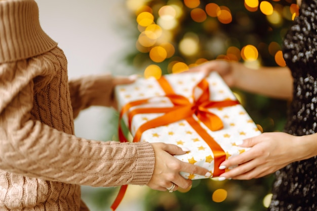 Geeft het cadeau Het ruilen van het kerstcadeau Jonge vrouw geeft een cadeau in een doos