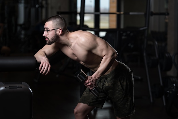 Geek man met halter die triceps traint