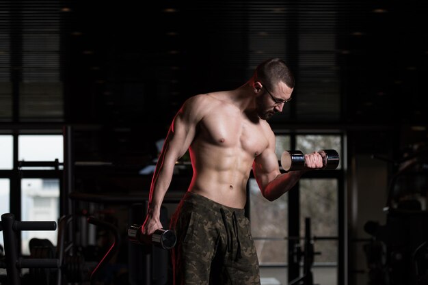 Geek Man With Dumbbell Exercising Biceps