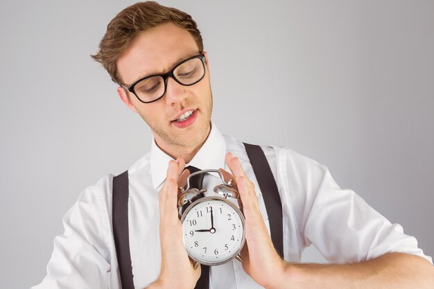 Geeky businessman holding alarm clock