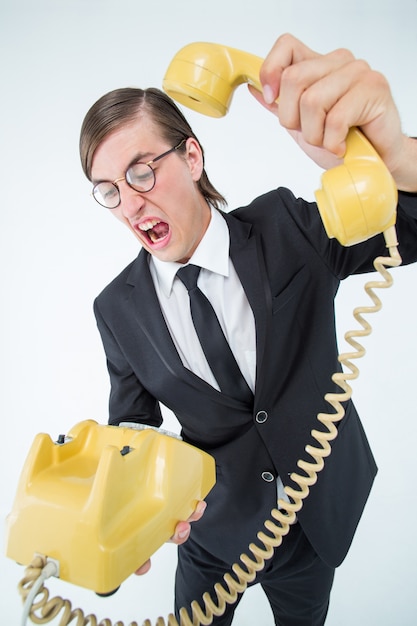 Geeky businessman shouting and hanging up the telephone