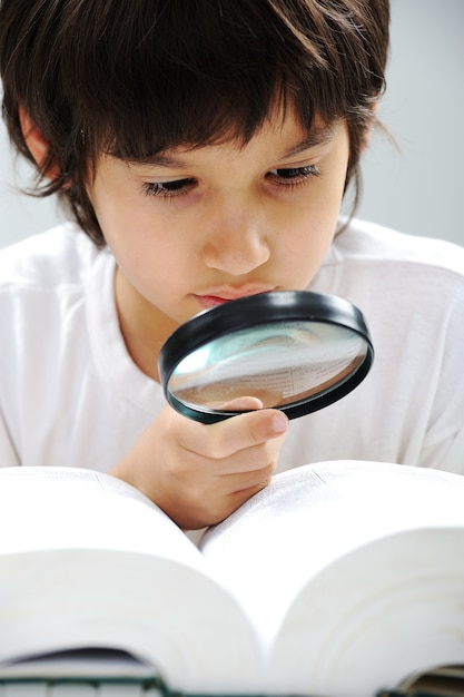 Geeky cute kid studying and wearing glasses