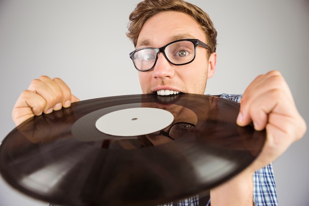 Geeky hipster biting vinyl record