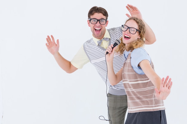 Geeky hipster couple singing into a microphone