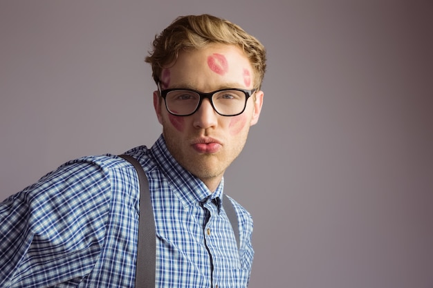 Geeky hipster covered in kisses