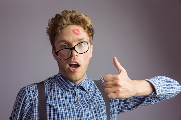 Geeky hipster covered in kisses