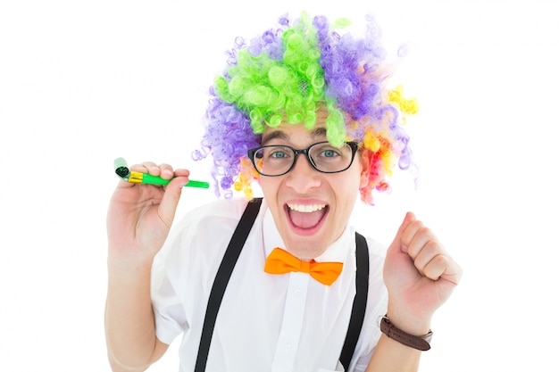 Geeky hipster die een partij van de de holdingspartij van de regenboogpruik draagt