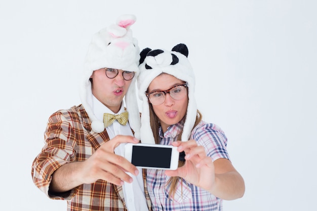 Geeky hipster paar dat selfie met slimme telefoon neemt