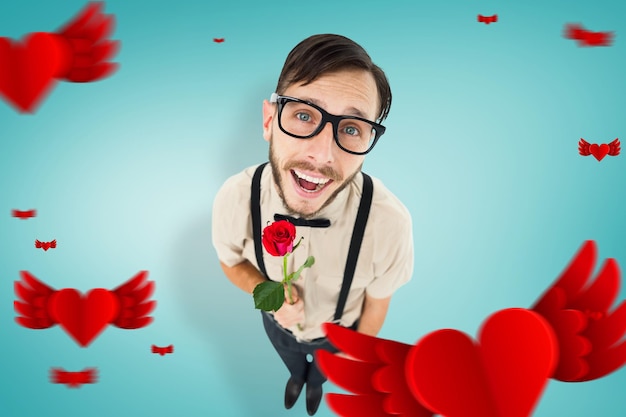 Geeky lovesick hipster holding rose  against blue vignette background