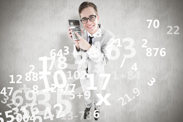 Geeky smiling businessman showing calculator against white background