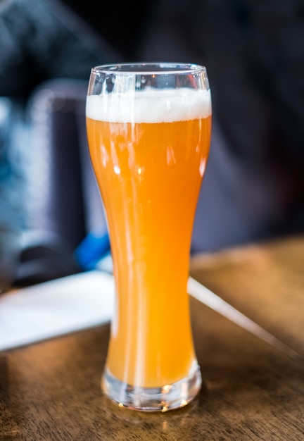 Geel bier van de tap met schuim in glas