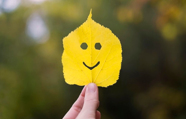 Foto geel blad in een hand gelukkig herfstconcept