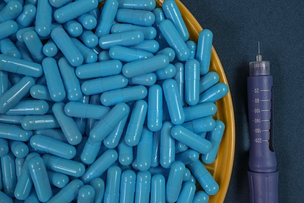 Geel bord vol blauwe medicijncapsules die een overdosis drugs vertegenwoordigen