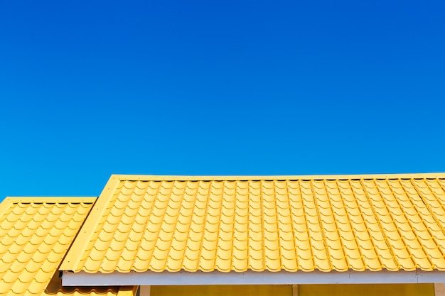 Geel dak met blauwe hemelachtergrond