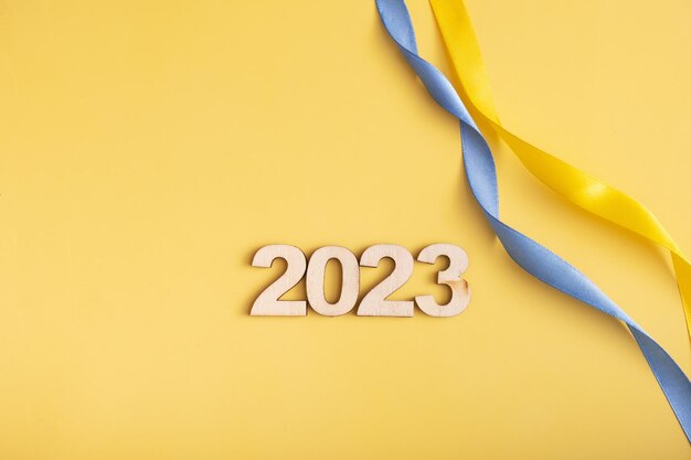 Geel en blauw lint met nummers 2023 op gele achtergrond