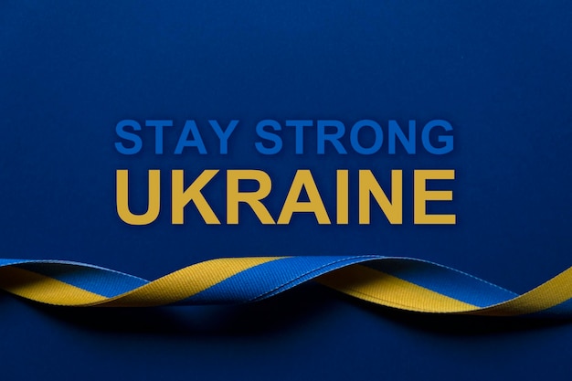 Geel en blauw Oekraïense nationale vlag kleuren stoffen lint en de boodschap Blijf sterk Oekraïne