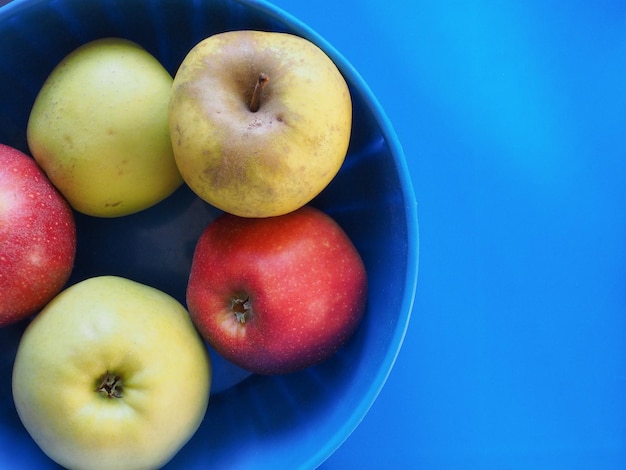 Geel en rood appelfruit eten over blauw met kopieerruimte