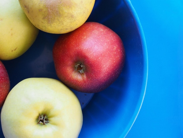 Geel en rood appelfruit eten over blauw